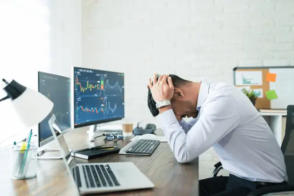 Trader dissapointed with hands above his head