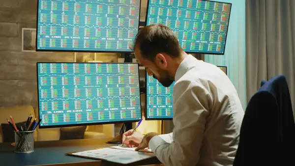 Trader studying in front of trading screens